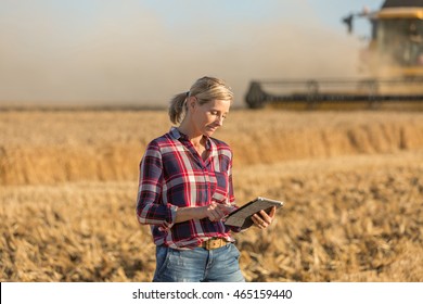 Female Farmer Standing In Wheat Field