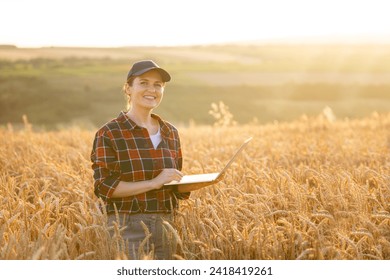 Female farmer working with laptop on wheat field. Smart farming and digital agriculture.	 - Powered by Shutterstock