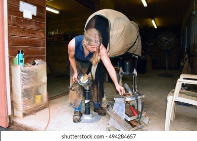 Female Farrier at work, shoeing a hunting horse