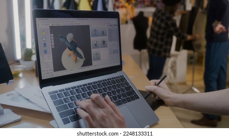 Female fashion designer develops future design of clothes in 3D modeling program on laptop using digital tablet and stylus. She works in atelier workshop. Fashion and technologies in business concept. - Powered by Shutterstock