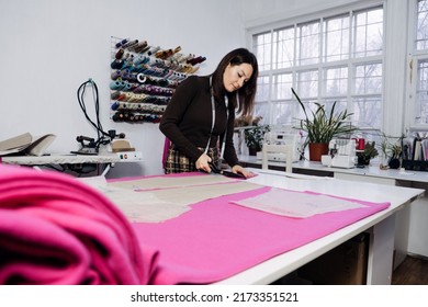 Female fashion designer tailor making sewing patterns at workplace in sewing studio. - Powered by Shutterstock