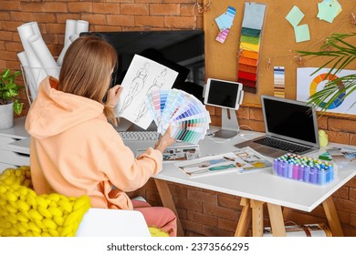 Female fashion designer working with color palettes at table in office - Powered by Shutterstock