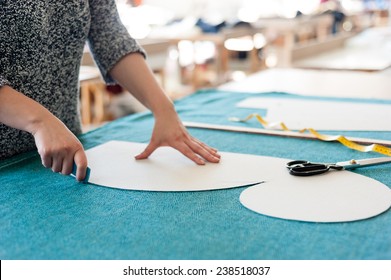 Female fashion designer working with sketches at studio and choosing cloth