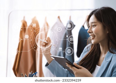 Female fashion designers design a product using a laptop computer with a digital tablet in a modern studio in the morning. - Powered by Shutterstock