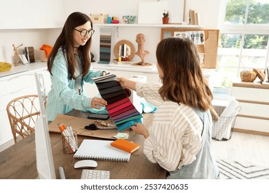 Female fashion designers working with fabric samples in studio - Powered by Shutterstock