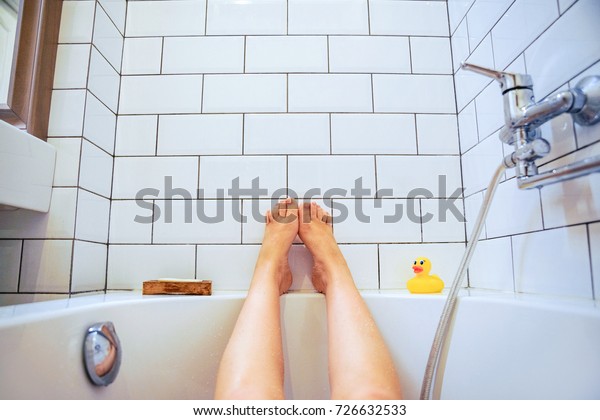 Female feet in\
bathroom first-person view. the girl lifted her legs up while\
enjoying bathing in the\
bathroom.
