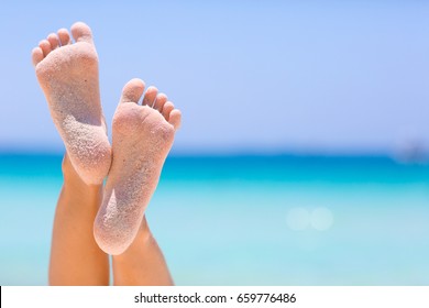 Female feet on blue sky and sea background