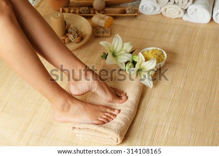 Female feet on soft towel over bamboo mat background