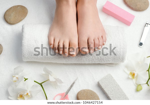 Female feet on towel roll. Nails
getting a fresh and accurate look during a pedicure
procedure.