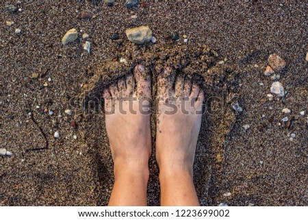 female feet on a wet sand background texture near water sea shore line nature local place