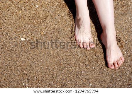 Female feet on wet sand