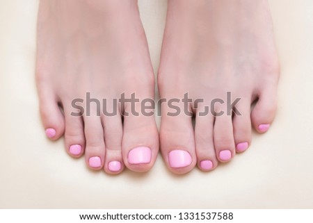 Female feet with a pink pedicure. Beauty saloon. Close-up