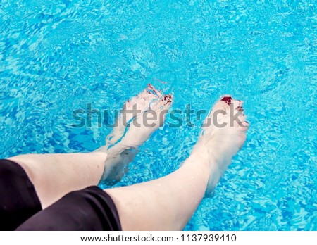 Female feet in the pool