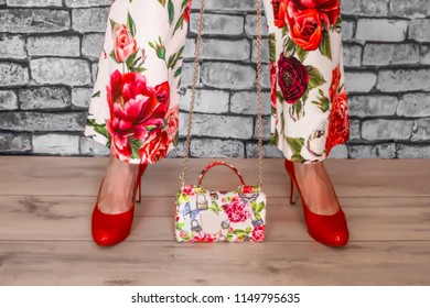 Female feet in red shoes and bag