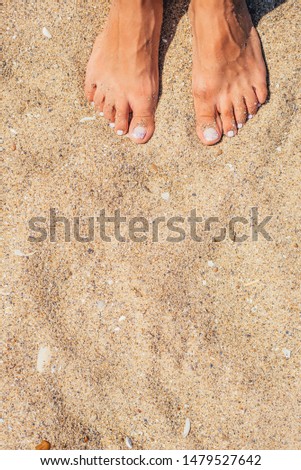 female feet in the sand