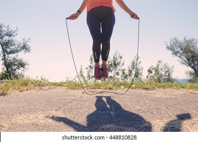 Female Feet In Sneakers Jumping On A Skipping Rope In Summer