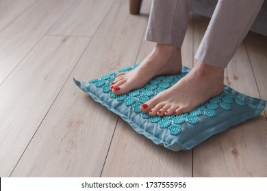 Female Feet Standing On Acupressure Mat. Self Acupuncture Massage. Woman Having Alternative Medicine Treatment.