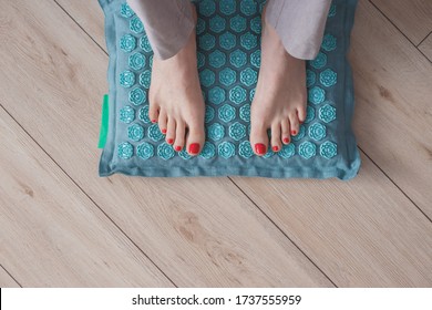 Female Feet Standing On Acupressure Mat. Self Acupuncture Massage. Woman Having Alternative Medicine Treatment.