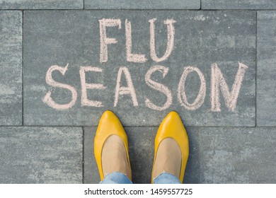 Female Feet With Text Flu Season Written On Grey Sidewalk.