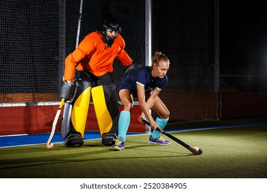 Female field hockey player attacking the goalie to score a goal. - Powered by Shutterstock