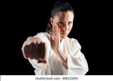 Female fighter performing karate stance on black background - Powered by Shutterstock