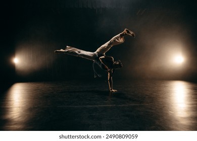 Female fighter training capoeira on black background - Powered by Shutterstock