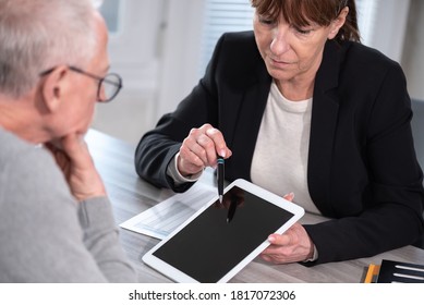 Female Financial Adviser Giving Information On Digital Tablet To Her Client