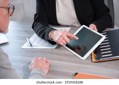 Female Financial Adviser Giving Information On Digital Tablet To Her Client