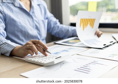 A female financier is reviewing company financial documents, monthly financial statement summary from the finance department. The concept of managing the company's finances for accuracy and growth. - Shutterstock ID 2025830078