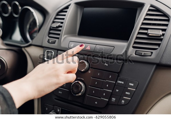 Female finger hitting car emergency light botton,\
woman pressing red triangle car hazard warning button, Warning of\
the danger and stop