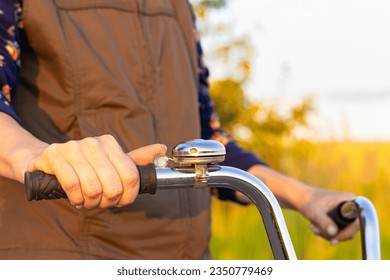 female finger presses on mechanical bicycle bell. hand holding the handlebars of a bicycle. girl riding a bike on a country road.  - Powered by Shutterstock