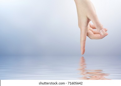 Female Finger Touching The Water Surface Level