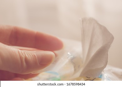 Female Fingers Takes A Wet Wipe From The Package. Side View, Closeup