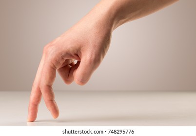 Female fingers walking on white surface