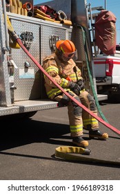 Female Fire Fighter Taking A Needed Break On The Back Of Engine Drinking Water From Working Training 