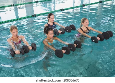Fitness-Unterricht für Frauen mit Aquaaerobic mit Schaumstoffglocken im Schwimmbad im Freizeitzentrum