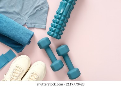 Female fitness flat lay, sneakers, dumbbells, on pastel pink background.Feminine sports, workouts, healthy lifestyle.