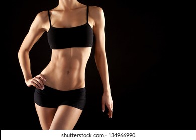 female fitness model posing on black background