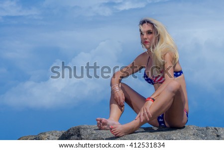 female fitness model posing on the Beach American Or 4th of July Concept Girl In American Flag Bikini At the Beach...