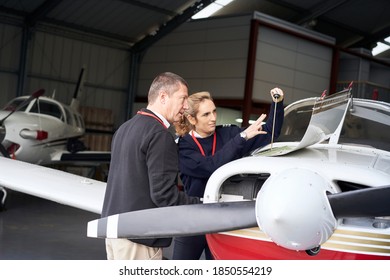 Female flight instructor teaching her student how to do the maintenance of the plane. - Powered by Shutterstock