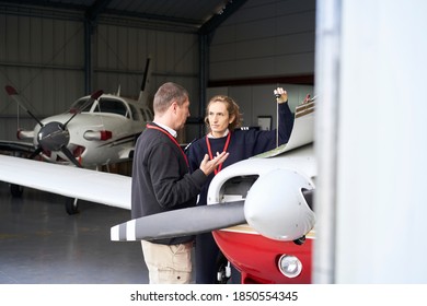 Female flight instructor teaching her student how to do the maintenance of the plane. - Powered by Shutterstock