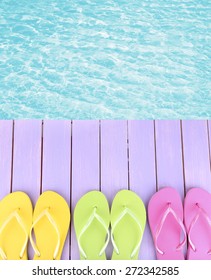 Female Flip Flops On Wooden Platform Beside Sea