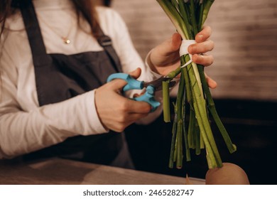 Female florist trimming flower stem at flower shop - Powered by Shutterstock