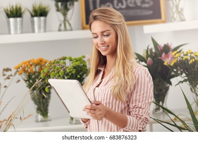 Female Florist Working In Flower Shop With Tablet