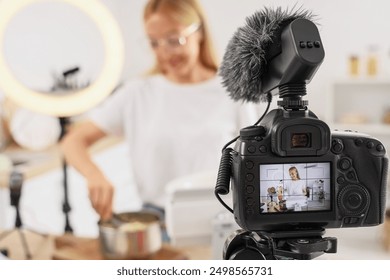 Female food blogger cooking pasta while recording video class on camera screen in kitchen, closeup - Powered by Shutterstock