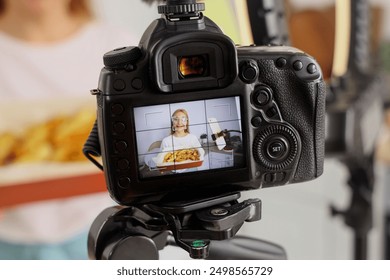 Female food blogger cooking potato while recording video class on camera screen in kitchen, closeup - Powered by Shutterstock