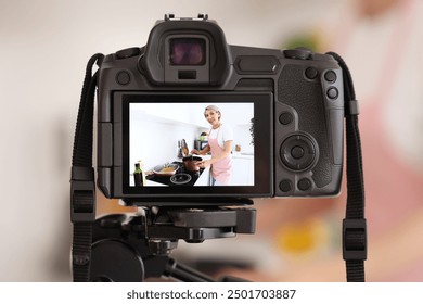 Female food blogger cooking soup while recording video on camera screen in kitchen, closeup - Powered by Shutterstock