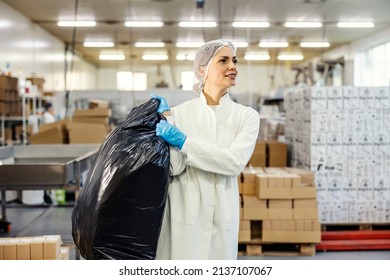 A Female Food Factory Worker Carry Trash Bag Out.