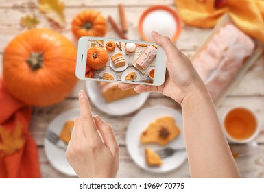 Female Food Photographer With Mobile Phone Taking Picture Of Tasty Pumpkin Pie, Top View