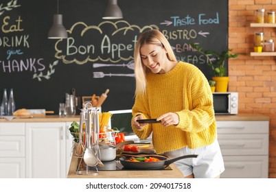 Female Food Photographer With Mobile Phone Taking Picture Of Tasty Fried Vegetables In Kitchen